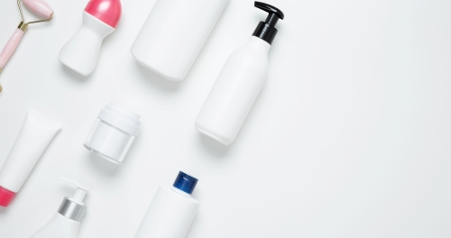 Unbranded white cosmetic bottles and tubes arranged on a clean white background.
